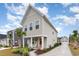 Charming two-story home with a walkway leading to the porch, lush landscaping, and a detached garage at 9000 Mabel Ct., Longs, SC 29568