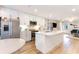 Open kitchen featuring stainless steel appliances, a large island, white cabinets, and wood floors at 9000 Mabel Ct., Longs, SC 29568