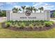 Entrance sign for North Village, surrounded by manicured landscaping and palm trees at 9000 Mabel Ct., Longs, SC 29568