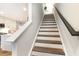 Staircase with wooden treads and white risers connects the home's levels at 9000 Mabel Ct., Longs, SC 29568