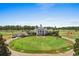 Stunning exterior view of grand clubhouse, featuring manicured lawn and flags from various countries on a sunny day at 100 Cypress Point Ct. # 105, Myrtle Beach, SC 29579