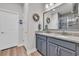 Modern bathroom with dual sinks, granite countertops, framed mirrors, and wood-look flooring at 1016 Longwood Bluffs Circle, Murrells Inlet, SC 29576