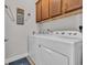 A well-lit laundry room featuring a white washer and dryer set and overhead storage cabinets at 1016 Longwood Bluffs Circle, Murrells Inlet, SC 29576