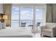 Bright bedroom with a king bed, seating area, and sliding glass doors leading to a private balcony with ocean views at 107 S Ocean Blvd. # 602, Myrtle Beach, SC 29577