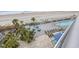 Aerial view of pool deck with palm trees, lounge chairs, tables, and a glimpse of the beach at 107 S Ocean Blvd. # 602, Myrtle Beach, SC 29577