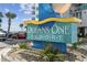 Attractive Oceans One Resort sign with tropical plants and a red sports car at 107 S Ocean Blvd. # 602, Myrtle Beach, SC 29577