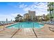 Outdoor pool surrounded by lounge chairs and tropical foliage with ocean views at 1105 S Ocean Blvd. # 706, Myrtle Beach, SC 29577