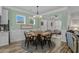 Light-filled dining room featuring a round table, modern chandelier, and open layout to the sunroom at 1118 Prescott Circle, Myrtle Beach, SC 29577