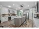 Bright and airy kitchen featuring white cabinetry, stainless steel appliances, a large island, and hardwood floors at 1118 Prescott Circle, Myrtle Beach, SC 29577