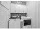 Modern laundry room with white cabinets, sleek washer and dryer, and stylish wallpaper at 1118 Prescott Circle, Myrtle Beach, SC 29577