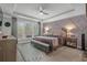 Comfortable bedroom featuring decorative accent wall, a ceiling fan, and large window at 1118 Prescott Circle, Myrtle Beach, SC 29577