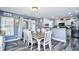 Bright dining room features a wooden table with white chairs, sliding door to the back and kitchen view at 1144 Harvest Circle # 1144, Myrtle Beach, SC 29579