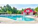 Community pool area with a red barn building and playground, surrounded by mature trees and lounge chairs at 1144 Harvest Circle # 1144, Myrtle Beach, SC 29579