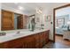 Bathroom with double sinks, granite countertop, wood cabinets and views into bedrooms at 136 Da Gullah Way # B, Pawleys Island, SC 29585