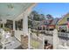 Inviting front porch view with white picket fence, rocking chairs, and patriotic American flags on a sunny day at 136 Da Gullah Way # B, Pawleys Island, SC 29585