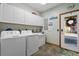 Bright laundry room featuring a washer and dryer set, ample storage, and a convenient utility sink at 136 Da Gullah Way # B, Pawleys Island, SC 29585