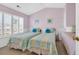 Bright bedroom with two twin beds, plantation shutters, and soft pink walls at 1450 Portrait Circle # 1450, Myrtle Beach, SC 29577