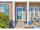 Close-up of a charming front door with decorative glass, surrounded by white pillars and lush greenery at 1450 Portrait Circle # 1450, Myrtle Beach, SC 29577