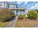 Inviting townhome entrance with a lush garden, walkway, and quaint front porch seating area at 1450 Portrait Circle # 1450, Myrtle Beach, SC 29577