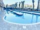 Outdoor swimming pool featuring a dolphin statue centerpiece, surrounded by palm trees and meticulous landscaping at 1501 S Ocean Blvd. # 841, Myrtle Beach, SC 29577