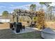 A backyard features a cozy seating area under a pergola, surrounded by lush greenery at 156 Legends Village Loop, Myrtle Beach, SC 29579