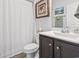 Well-lit bathroom features a dark vanity, white toilet, framed artwork, and a shower with curtain at 156 Legends Village Loop, Myrtle Beach, SC 29579