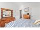 Comfortable bedroom with wooden dressers, a mirror, and a bed bathed in natural light at 156 Legends Village Loop, Myrtle Beach, SC 29579