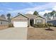 Inviting single-story home with a brick facade, a two-car garage, and a well-kept lawn at 156 Legends Village Loop, Myrtle Beach, SC 29579