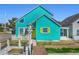 Inviting turquoise home featuring a bright yellow door and delightful beach-themed decor, creating a cheerful curb appeal at 1607 Havens Dr., North Myrtle Beach, SC 29582