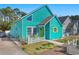 Charming home with a distinctive turquoise exterior, a well-manicured lawn, and delightful beach-themed decorations at 1607 Havens Dr., North Myrtle Beach, SC 29582