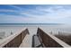 Wooden boardwalk leads to a beautiful beach with clear blue skies and ocean views at 1625 S Ocean Blvd. # 403, North Myrtle Beach, SC 29582