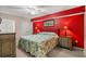 Bedroom featuring colorful bedspread, red accent wall and matching lamps at 1625 S Ocean Blvd. # 403, North Myrtle Beach, SC 29582