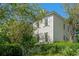 Two-story home with white siding, grey shutters, and surrounded by lush greenery at 201 Broad St., Georgetown, SC 29440