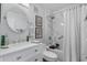 Well-lit bathroom featuring a marble tiled shower and a round mirror over a vanity sink at 210 North Ocean Blvd. # 330, North Myrtle Beach, SC 29582