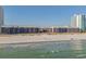 View from the water of a beachfront condo complex with balconies and people walking on the beach at 210 North Ocean Blvd. # 330, North Myrtle Beach, SC 29582