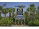 Welcome to North Myrtle Beach sign framed by palm trees, flowers, blue skies and American flag at 218 Landing Rd. # G, North Myrtle Beach, SC 29582