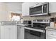 Well-lit kitchen features stainless steel appliances, granite countertops, white cabinetry, and black tile flooring at 2241 Waterview Dr. # 527, North Myrtle Beach, SC 29582