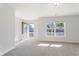 Bright, carpeted living room features a window and a glass paneled door leading to the outside at 227 Walnut Grove Ct., Myrtle Beach, SC 29579