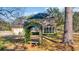 Exterior view of a brick home, showing the screened porch, attached garage, and vine-covered pergola at 268 Wraggs Ferry Rd., Georgetown, SC 29440