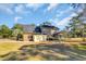 Exterior back view of a brick home with a screened-in porch, attached garage, and mature landscaping at 268 Wraggs Ferry Rd., Georgetown, SC 29440