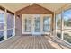 View of a covered porch with a wood floor, brick siding, and an exterior wall light at 268 Wraggs Ferry Rd., Georgetown, SC 29440