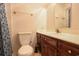 Bathroom featuring a cherry wood vanity, toilet, sink and matching mirror at 300 19Th Ave. S, Myrtle Beach, SC 29577