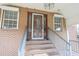 Inviting front entryway featuring a classic wood door, brick facade, and a small set of brick stairs with metal handrails at 300 19Th Ave. S, Myrtle Beach, SC 29577