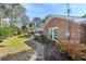 Well-maintained backyard featuring a charming brick pathway, lush landscaping, and a cozy ambiance at 304 Queens Rd., Myrtle Beach, SC 29572