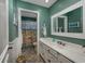 Bathroom with beach themed shower curtain and green walls, white cabinets, and a vanity with a large mirror at 304 Queens Rd., Myrtle Beach, SC 29572