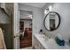 Bathroom featuring modern lighting, white cabinets, and a view to living room beyond the doorway at 304 Queens Rd., Myrtle Beach, SC 29572