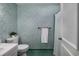 Retro bathroom showcasing patterned green wallpaper, matching tile floor, and classic white fixtures at 304 Queens Rd., Myrtle Beach, SC 29572