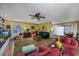 Spacious living room featuring a ceiling fan, carpet and tile flooring, a large window and open access to the kitchen at 304 Queens Rd., Myrtle Beach, SC 29572