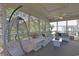 Cozy screened porch with seating, decorative pillows, ceiling fan, and hanging chair at 306 Oak Lake Circle, North Myrtle Beach, SC 29582