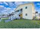 Back of an elevated home featuring stairs leading to a screened porch and well-maintained lawn at 314 58Th Ave. N, North Myrtle Beach, SC 29582